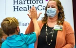 Un enfant de 10 ans tape dans la main de la professionnelle de santé Colleen Teevan après avoir reçu le vaccin de Pfizer contre le Covid-19, le 2 novembre 2021 à Hartford dans le Connecticut