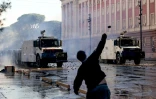 Un manifestant lance un pavé sur des policiers lors d’une manifestation antigouvernementale à Tirana, le 16 octobre 2026 en Albanie