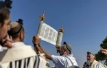 Des colons israéliens prient lors de la réouverture d'une colonie à Ganim, en Cisjordanie occupée, le 13 août 2026