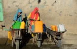 Des jeunes filles remplissent des jerrycans avec de l'eau potable à Kandahar, le 24 mai 2022 en Afghanistan