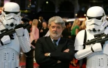 Le réalisateur américain George Lucas, encadré par des personnages de sa saga "Star Wars", lors d'une première à Londres le 16 mai 2005.