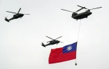 Un hélicoptère CH-47 Chinook (en haut à droite) et des hélicoptères UH-60 Black Hawk volent en formation avec le drapeau taïwanais lors des célébrations de la fête nationale, le 10 octobre 2024 à Taipei