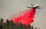 Un avion bombardier d'eau largue du "retardant", un produit coloré (rouge) qui revêt la végétation d'une pellicule ignifuge, le long d'une crête pendant un incendie à Lakehead, en Californie, le 2 juillet 2021