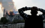 Un passant regarde Notre-Dame en flammes le 15 avril 2019