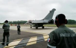 Des membres de la Force aérienne et spatiale française observent un avion de chasse Rafale roulant sur le tarmac de la base aérienne 115 à Orange, dans le Vaucluse, le 28 avril 2026