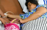 Dinar prend soin le 6 octobre 2018 de sa petite fille à laquelle elle a donné naissance sur un navire-hôpital après le terrible séisme suivi d'un tsunami qui a frappé Palu sur l'île des Célèbes en Indonésie 
