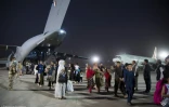 Photo fournie par l'Etat-major français des Armées le 26 août 2021, d'Afghans évacués de l'aéroport de Kaboul débarquant d'un avion militaire français à la base aérienne d'Al Dhafra, près d'Abou Dabi