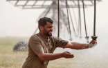 Un cultivateur, Zain al-Abidin, règle un arroseur géant dans son champ de blé, dans le désert de Najaf, dans le sud de l'Irak, le 10 avril 2025
