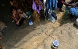 Des réfugiés Rohingyas attendent qu'une lanterne se charge grâce à l'énergie solaire, dans un camp de Kutupalong au Bangladesh, le 7 octobre 2017