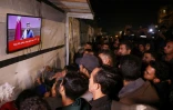 Des Palestiniens regardent à la télévision une conférence de presse du Premier ministre du Qatar, Mohammed ben Abdelrahmane Al-Thani, dans une rue de Khan Younès dans le sud de la bande de Gaza, le 15 janvier 2025