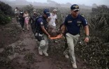 Des policiers évacuent un blessé lors de l'érruption du volcan Fuego, dans le village d'El Rodeo village, à 35 km au sud de la ville Guatemala le 3 juin 2018