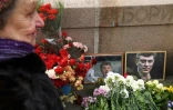 Une vieille femme dépose des fleurs le 27 février 2020 à l'endroit où a été abattu par balles il y a cinq ans l'opposant russe Boris Nemtsov, sur un pont près du Kremlin
