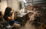Christian Magdeleine, luthier pose nu avec une guitare en fabrication, devant la photographe Caroline Gilles, à Bastia le 19 novembre 2020 pour alarmer sur son "agonie" 