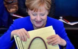 La chancelière allemande Angela Merkel sort un dossier de son sac avant une réunion du groupe parlementaire CDU/CSU à Berlin, le 2 juillet 2018