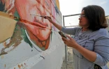 L'artiste irakienne Wijdan al-Majed met les dernières touches à l'une de ses fresques à Bagdad, le 26 avril 2022