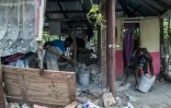 Des habitants évacuent des gravats dans une maison sévèrement endommagée par le séisme en Haïti, le 18 août 2021