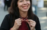 Elif Eralp, la candidate de Die Linke à Berlin, montre son pendentif sur lequel est inscrit "Mietendeckel" ("Plafonnement des loyers"), en campagne électorale le 18 septembre 2026 dans la capitale allemande