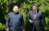Photo fournie le 9 mai 2018 par l'agence nord-coréenne Kcna du leader nord-coréen Kim Jong Un (g) et du président chinois Xi Jinping, lors d'une rencontre à Dalian le 8 mai 2018, en Chine