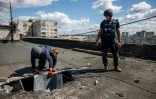 Des démineurs inspectent le toit d'un immeuble endommagé par un missile à Kharkiv, le 28 avril 2022  