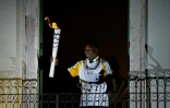 Le dieu du football, le Brésilien Pelé, pose avec la torche olympique au balcon du musée qui lui est dédié, à Santos, près de Sao Polo, le 22 juillet 2016 