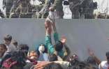 Photo extraite d'une vidéo filmée par Omar Haidiri montrant un militaire américain attrapant un bébé tendu par des civils afghans devant le mur d'enceinte de l'aéroport de Kaboul, le 19 août 2021