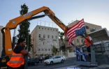 Un ouvrier à Jérusalem s'apprête à accrocher un drapeau américain le 12 juillet 2022, à la veille de l'arrivée du président Joe Biden