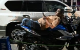 Un homme se repose sur sa moto en attendant de pouvoir faire le plein dans une station-service de Dacca, au Bangladesh, le 21 avril 2026