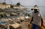 Un homme vient de déverser des déchets dans un canal le long de la baie de Hann à Dakar, le 18 octobre 2023
