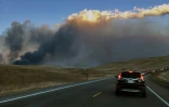 Une voiture de police roule sur une autorouté près d'un incendie, le 30 décembre 2021, à Rocky Flats, Broomfield, dans le Colorado