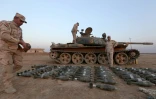 Des soldats irakiens montrent les obus de mortiers près d'un char pris aux jihadistes du groupe EI, à Qaraqosh, à 30 km à l'est de Mossoul