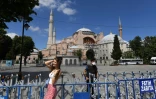 Une femme pose pour une photo devant Sainte-Sophie, à Istanbul le 11 juillet 2020