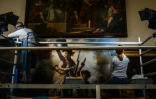 Des restaurateurs travaillent sur le tableau "La liberté guidant le peuple" d'Eugène Delacroix, dans un laboratoire du Musée du Louvre à Paris, le 28 février 2024