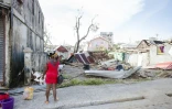 une femme observe les restes d'une maison à Roseau, capitale de la Dominique, le 21 septembre 2017 après le passage de l'ouragan Maria