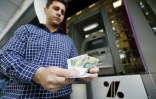 Un homme retire des rials iranien d'un distributeur de billets à Téhéran, le 31 juillet 2018