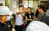 Un policier en civil demande à Niki So, une habitante d'un village de Kwu Tung, de quitter son domicile qui doit être démoli pour faire place à un vaste projet de pôle technologique, le 23 juin 2026 dans les Nouveaux Territoires à Hong Kong