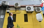 Un homme passe devant des blocs de climatiseurs le 2 mai 2024 à Tokyo