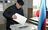 Un homme dépose son bulletin dans un bureau de vote de Bakou pour les élections législatives en Azerbaïdjan, le 9 février 2020