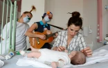 Des clowns de l'association "Le Rire Medecin" avec un enfant malade le 25 juillet 2016 à l'hôpital Necker à Paris