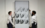 Des employés de Sotheby's tiennent le célèbre tableau d'Andy Warhol "Nine Marylins", le 5 novembre 2021 à New York