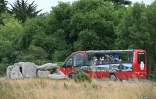 Des touristes prennent des photos des Mégalithes de Carnac, lors d'une visite en bus, le 27 juin 2025 dans le Morbihan