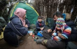 Une famille dans un camp monté par des migrants à Grodno près de la frontière entre le Bélarus et la Pologne, le 13 novembre 2021 