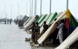 Des personnes ayant fui leurs maisons inondées sont installées dans des tentes le long d'une route à Sukkur, dans la province de Sindh, le 27 août 2022