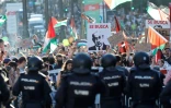 Des manifestants propalestiniens brandissent une pancarte avec un portrait du Premier ministre israélien Benjamin et la mention "Recherché", après avoir envahi les rues pendant la 21e et dernière du Tour d'Espagne cycliste, le 14 septembre 2025