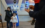 Des enfants posent pour une photo avec un robot-serveur dans le restaurant White Fox, Ă Mossoul, en Irak, le 17 novembre 2021