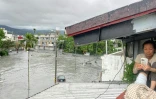 Une femme s'est réfugiée sur le toit de sa maison après la rupture d'un barrage et un glissement de terrain à Taïwan, le 23 septembre 2025
