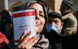 Une manifestante brandissant une copie de la Constitution tunisienne lors d'un rassemblement à Tunis, le 13 février 2022