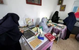 Des femmes restaurent des exemplaires du Coran, anciens ou abîmés, dans un atelier à Tripoli, le 22 mars 2022 en Libye