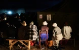 Des électeurs font la queue devant un bureau de vote à la nuit tombée, le 23 août 2023 à Bulawayo, au Zimbabwe