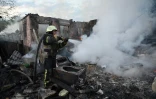 Des pompiers éteignent un incendie après une attaque de drones russes dans les environs de Kharkiv, le 21 mai 2024 en Ukraine