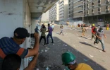 Des manifestants irakiens tentent d'échapper aux grenades de gaz lacrymogène tirées par les forces de sécurité, à Bagdad, le 10 novembre 2019
